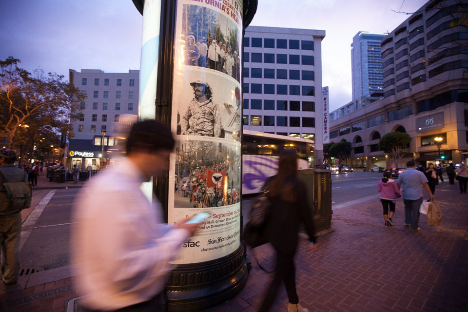 One of the 40 kiosks with poster-sized prints of selected images from the exhibit is located on Market Street at Powell Street and holds the work of Lou Demmatteis.