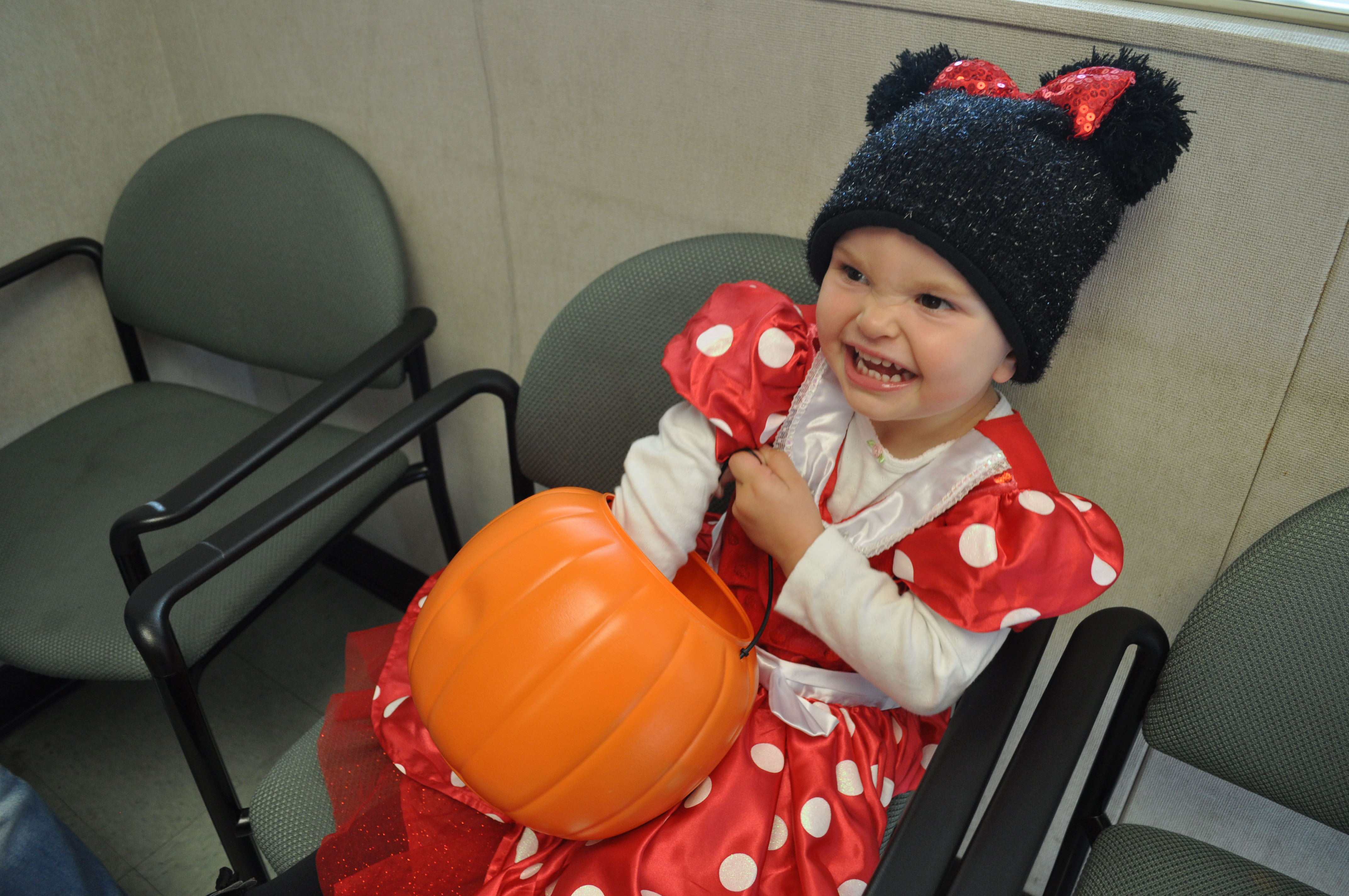 Chanel, dressed as Minnie Mouse, reaches into her basket for more candy at the Extended Opportunity Programs and Services building while trick-or-treating.