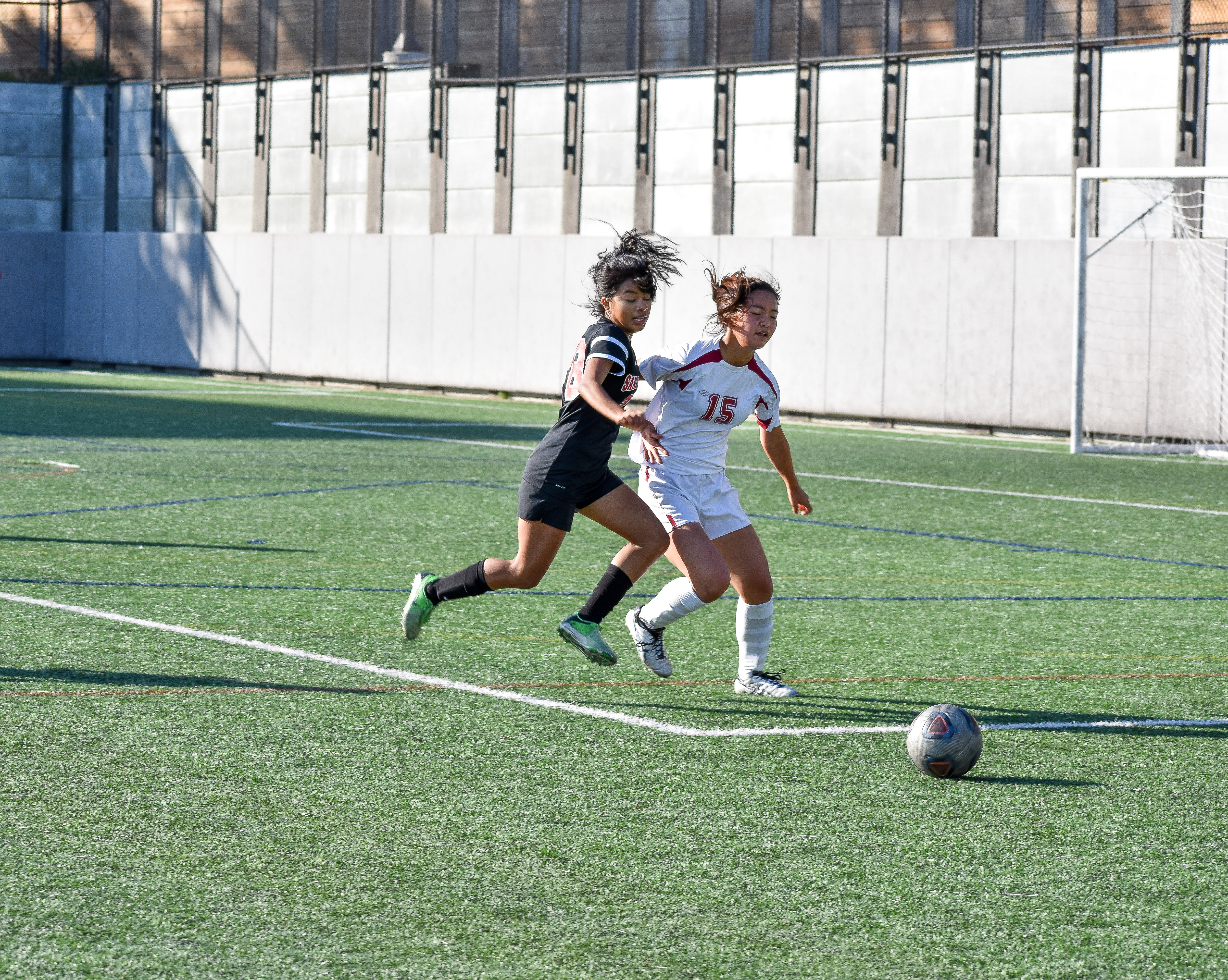 Midfielder Illena Mercado (#8)  muscles out the opponent while going after the ball. Photo by Julia Fuller. 