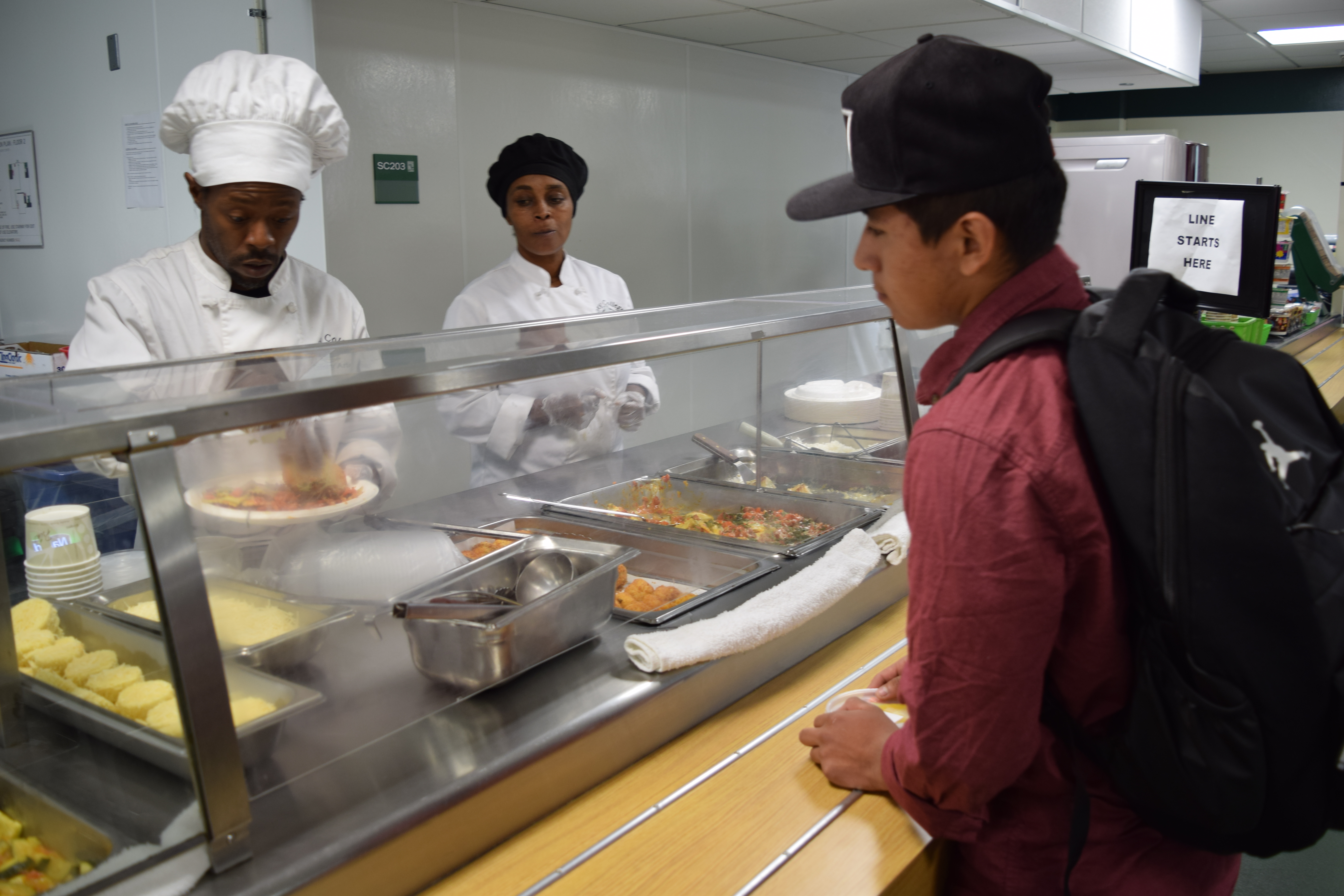 Student Hernandez and culinary student Jabari Shaw under the attentive eyes of another Laney college student Monique Miles. Nov. 29, 2017. (Photo by Barbara Muniz)