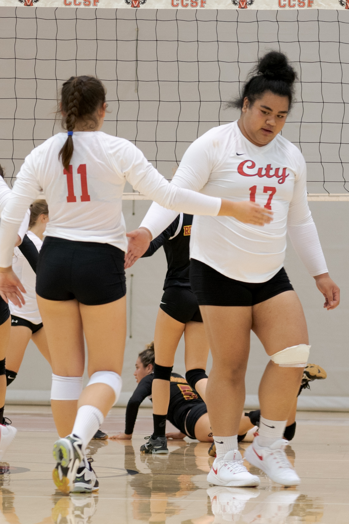 After successfully blocking an attack, Allysha Seuteni (#17) and Sydney Huddseston (#11) cheer each other on, Friday, September 21, 2018 at the Ocean Campus Welness Center Gym. Photo by Cliff Fernandes/The Guardsman