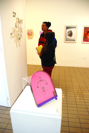 City College students Marissa Juvera and Armand Beltran adminre artwork at the "Pap Art" exhibit at the City Arts Gallery in the Visual Arts Building. JOSEPH PHILLIPS / THE GUARDSMAN