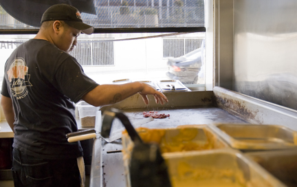 Phat Philly employee Miguel Poot prepares some beef for a sandwich on the grill at the 24th and Valencia St. restaurant on March 14. CHLOE ASHCRAFT / THE GUARDSMAN