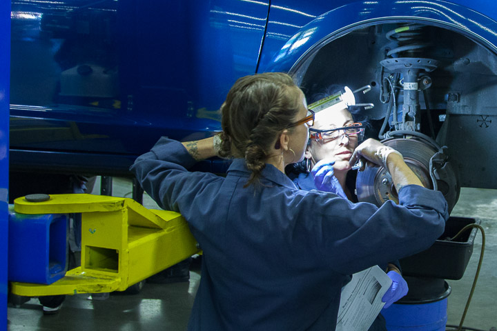 Mrs. Lisa Duke(left) Automitive mechanics instructor shows Lucia Mampieri how to measure the brake pads on a car. Photo by JuanPardo/The Guardsman