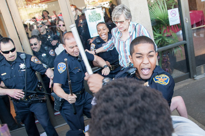 SFPD officer brandishes his baton attempting to stop City College students from entering Conlan Hall during a protest on Thursday, March 13, 2014. Over 15 students forced entry and staged an overnight sit in. Photo by Santiago Mejia/The Guardsman 