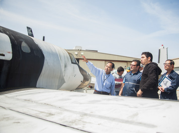 Instructor Hoi Ko, left, gestures to the Sabreliner T-39 aircraft and lectures his students on its components.