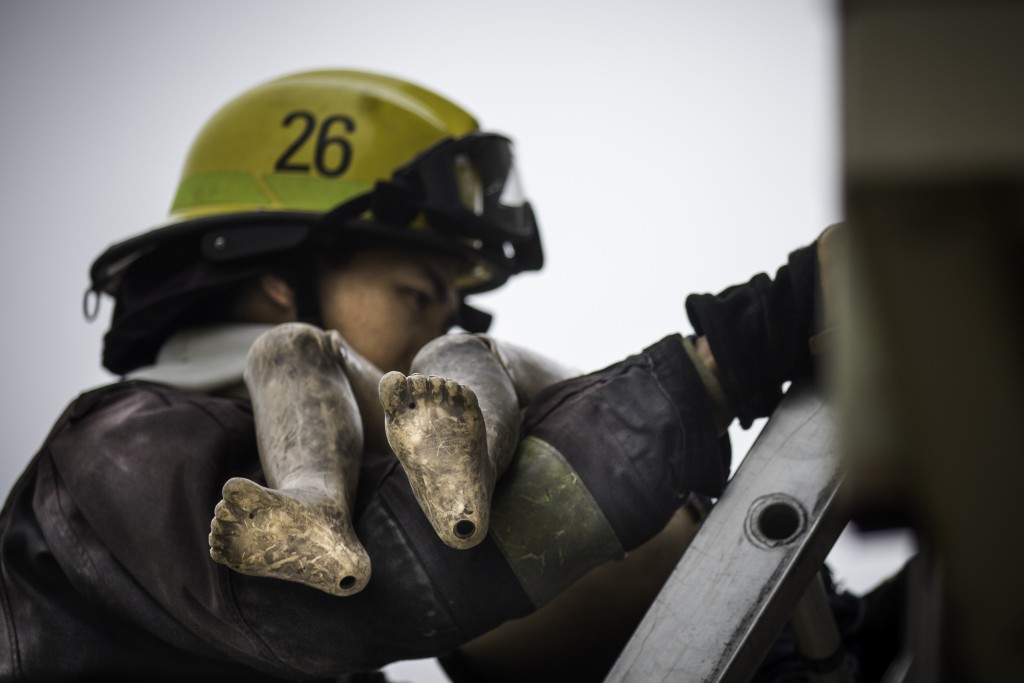 A fire cadet practices rescuing a victim during a search and rescue drill at the live fire training that cumulated the 18 weeks of preparation for 29 fire cadets of City College’s Class 15 Fire Fighter One Academy at South San Francisco Fire Department Station 61 on Saturday, May 16, 2015. (Photo by Nathaniel Y. Downes/The Guardsman)