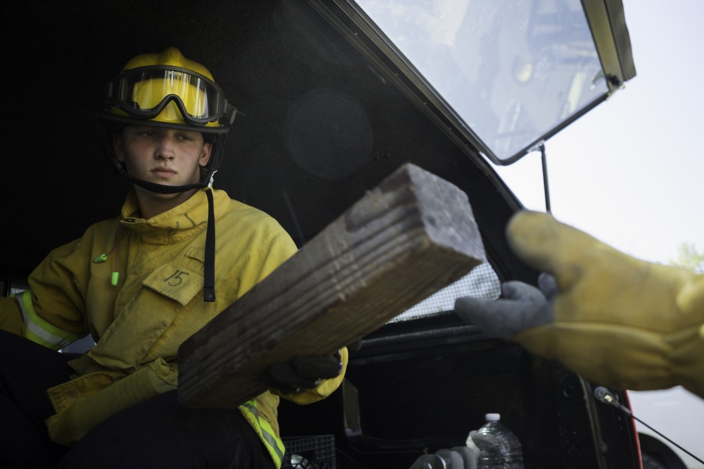 Fire cadet Nick Oatley from City College’s Fire Fighter One Academy’s Class 15 passes a cribbing used to stabilize and unstable car during the auto extrication training at San Jose Pick and Pull on Saturday, April 18, 2015. (Photo by Nathaniel Y. Downes/The Guardsman)