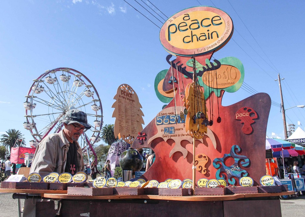  Joe Murphy a.k.a Joe Peace, a creator of The Peace Chain, sets up his booth at the festival. Peace has crafted 570 clay pendants and multiple works with words for “Peace” in different languages for more than 24 years. (Photo by Calindra Revier/The Guardsman)