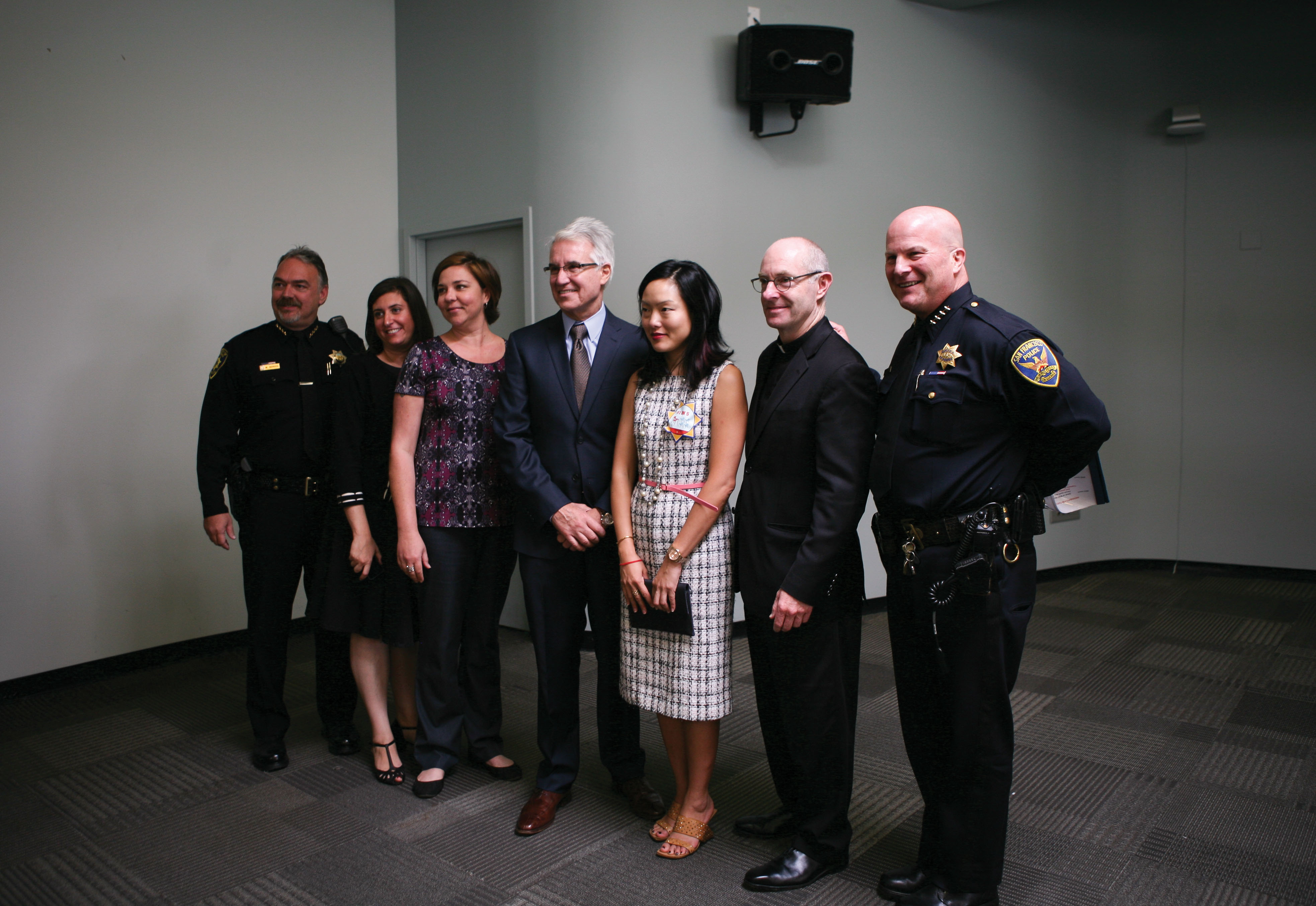 (L-R) UCSF police chief Mike Denson, USF interim vice provost of student life Julie Orio, USF Title IX coordinator Anne Bartkowski, District Attorney George Gascon, Supervisor Jane Kim, USF President Paul Fitzgerald, and SF Police Chief Greg Suhr gather for a group photo after a press conference about a new program to combat sexual assault on college campuses in SF. (Photo by Anna Vignet/Contributor)