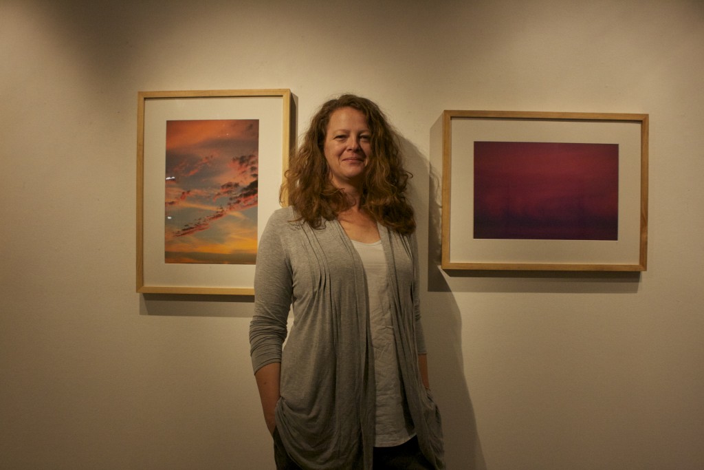 City College photography student, Adrienne Johnson, in front of her images on display from her series “Agathokakological,” at Gallery Obscura on Oct. 15, 2015. (Photo by Cassie Ordonio/The Guardsman)