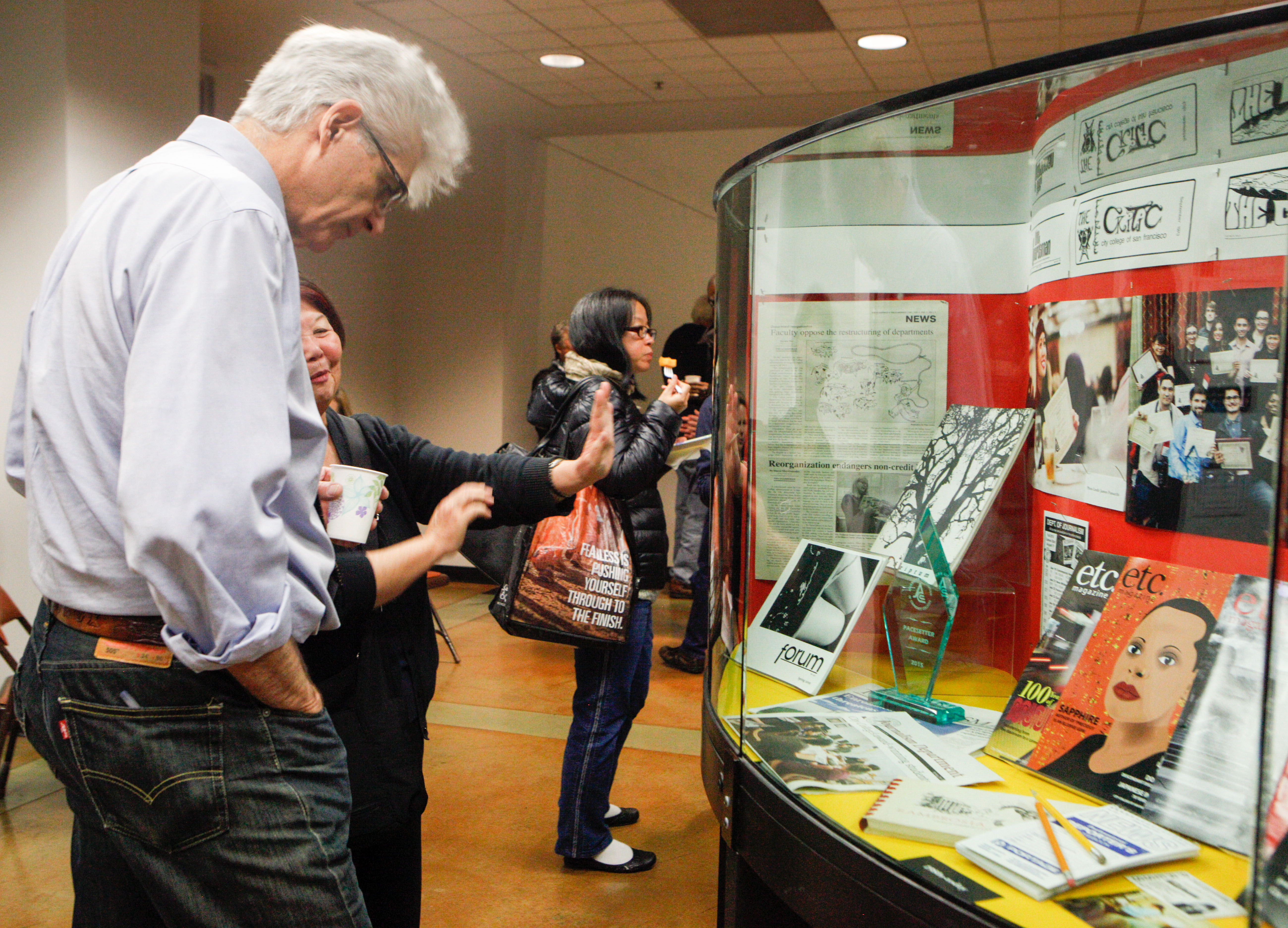 Attendees of the 80th Anniversary celebration of City College’s newspaper, The Guardsman, view photos and historical information on display in the Rosenberg Library on Thursday Nov. 12, 2015. (Photo by Fran Smith/ The Guardsman)