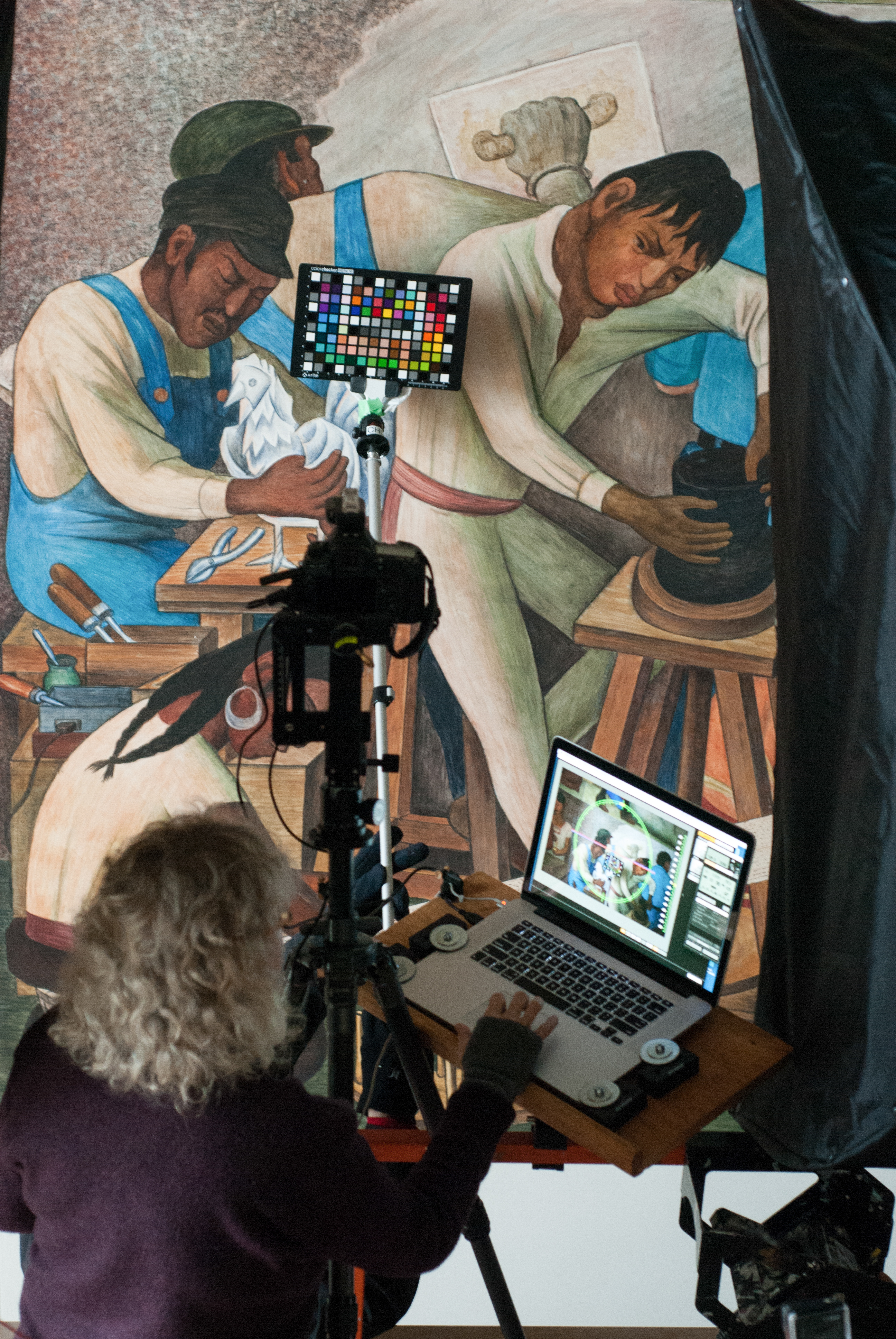 Carla Schroer of the non-profit, Cultural Heritage Imaging, setting up the laptop and camera so she can scan the Diego Rivera Mural located in the Diego Rivera Theater at the main campus in San Francisco. (Photo by Franchon Smith/ The Guardsman)