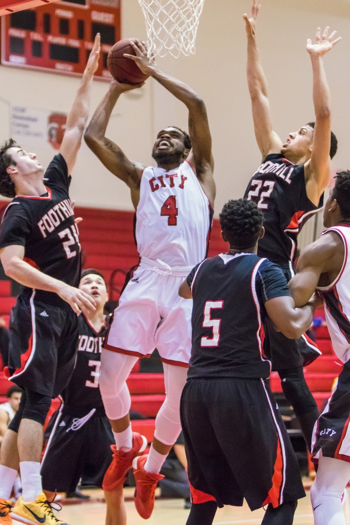 Sophomore guard Shon Briggs (4) weaves through four Foothill College defenders on his way to the net for a layup. (Photo by Peter Wong/Special to The Guardsman)