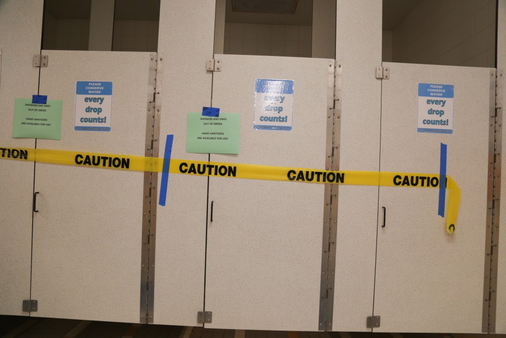 Caution tape marks off Wellness Center bathroom stalls after a leak was caught in a room adjacent to the water system on april 11, 2016. (Photo by Gabriella Angotti Jones/The Guardsman)