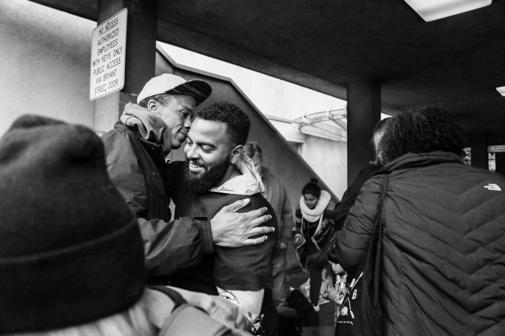 James Burch, left, and Christopher Rudd, right, embrace after being arrested during a rally against alleged police brutality on May 6, 2016. They reunite outside the San Francisco County Jail at 850 Bryant St. on May 7, 2016.(Photo by Natasha Dangond/Special to The Guardsman)