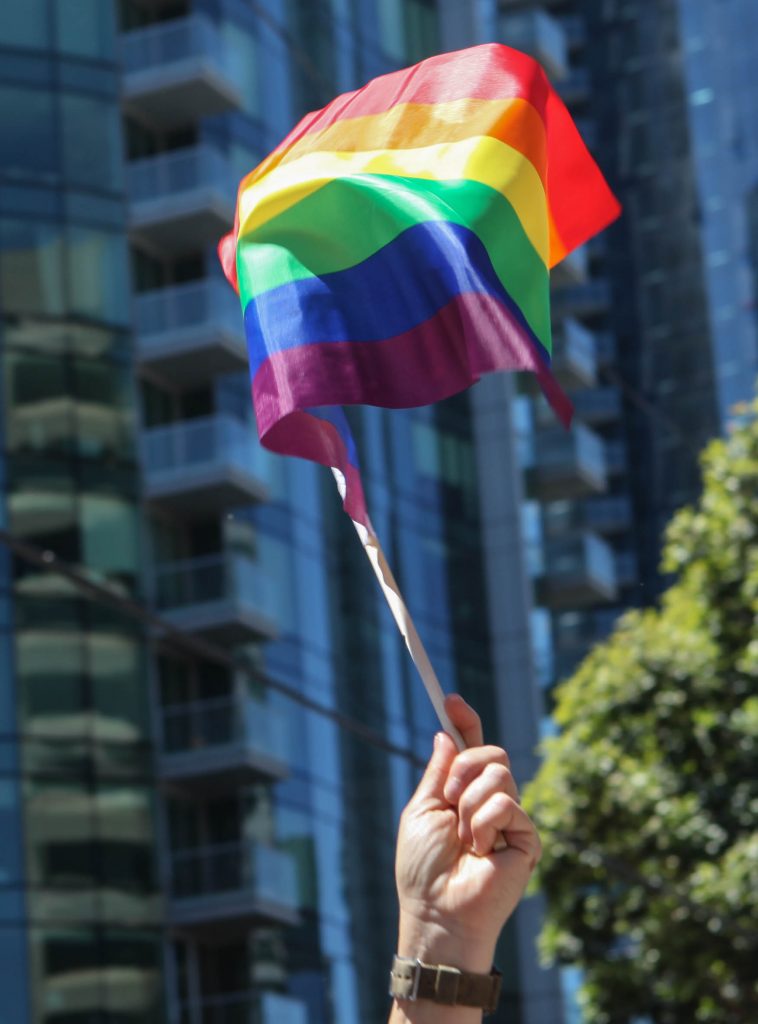Board of Trustee Vice President, Thea Selby holds a rainbow pride flag before the start of the San Francisco Pride Parade on June 26, 2016. (Photo by Cassie Ordonio/The Guardsman)