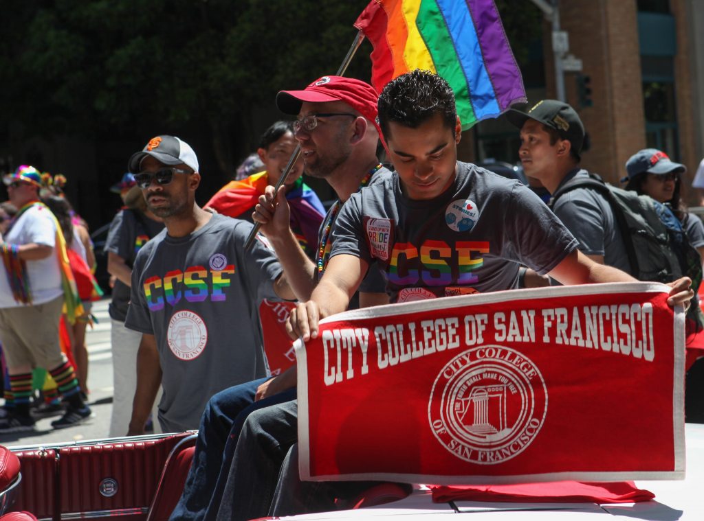 City College Board of Trustee member Alex Randolph displays a City College banner while Board of Trustee President Rafael Mandelman holds a pride flag while waiting for the San Francisco Pride Parade to begin on June 26, 2016. (Photo by Cassie Ordonio/The Guardsman)