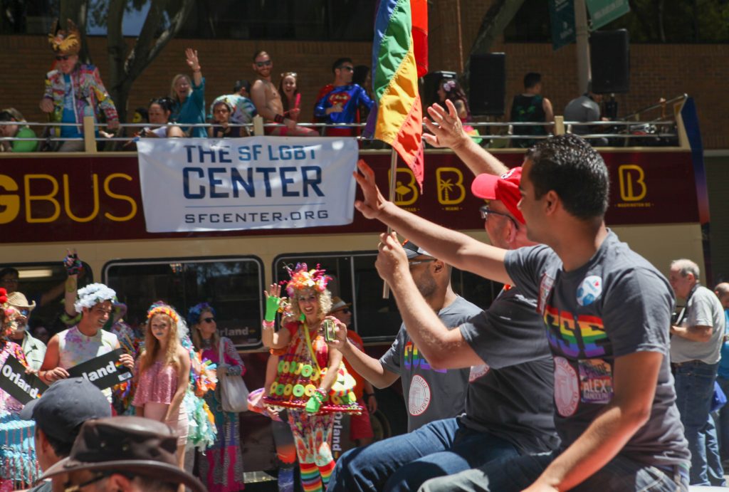 Board of Trustee members Rafael Mandelman and Alex Randolph wave to the crowd on Spear Street as they ride along the San Francisco Pride Parade route on June 26, 2016. (Photo by Cassie Ordonio/The Guardsman)