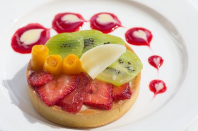 The Educated Palate served a fresh fruit tart with sliced strawberry and kiwi topped with mango flowers on its Sept. 28 dessert menu. White chocolate hearts garnish the plate atop fruit sauce. (Photo by David Horowitz/The Guardsman)