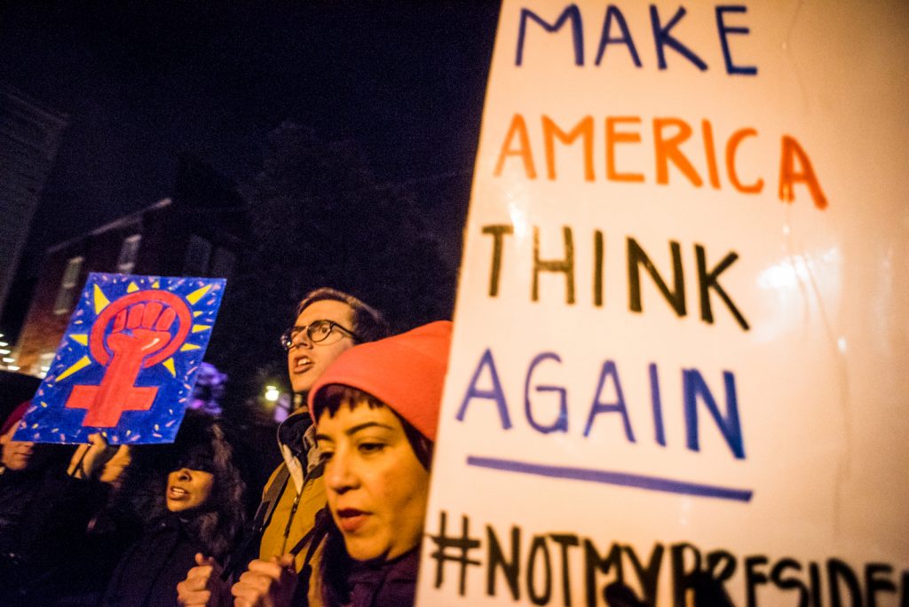 A woman bobs sign reading "Make America think Again, "while protesting against, "#notmypresident," during inagural march Ja. 20, 2017. (Photo by Gabriela Reni/The Guardsman)