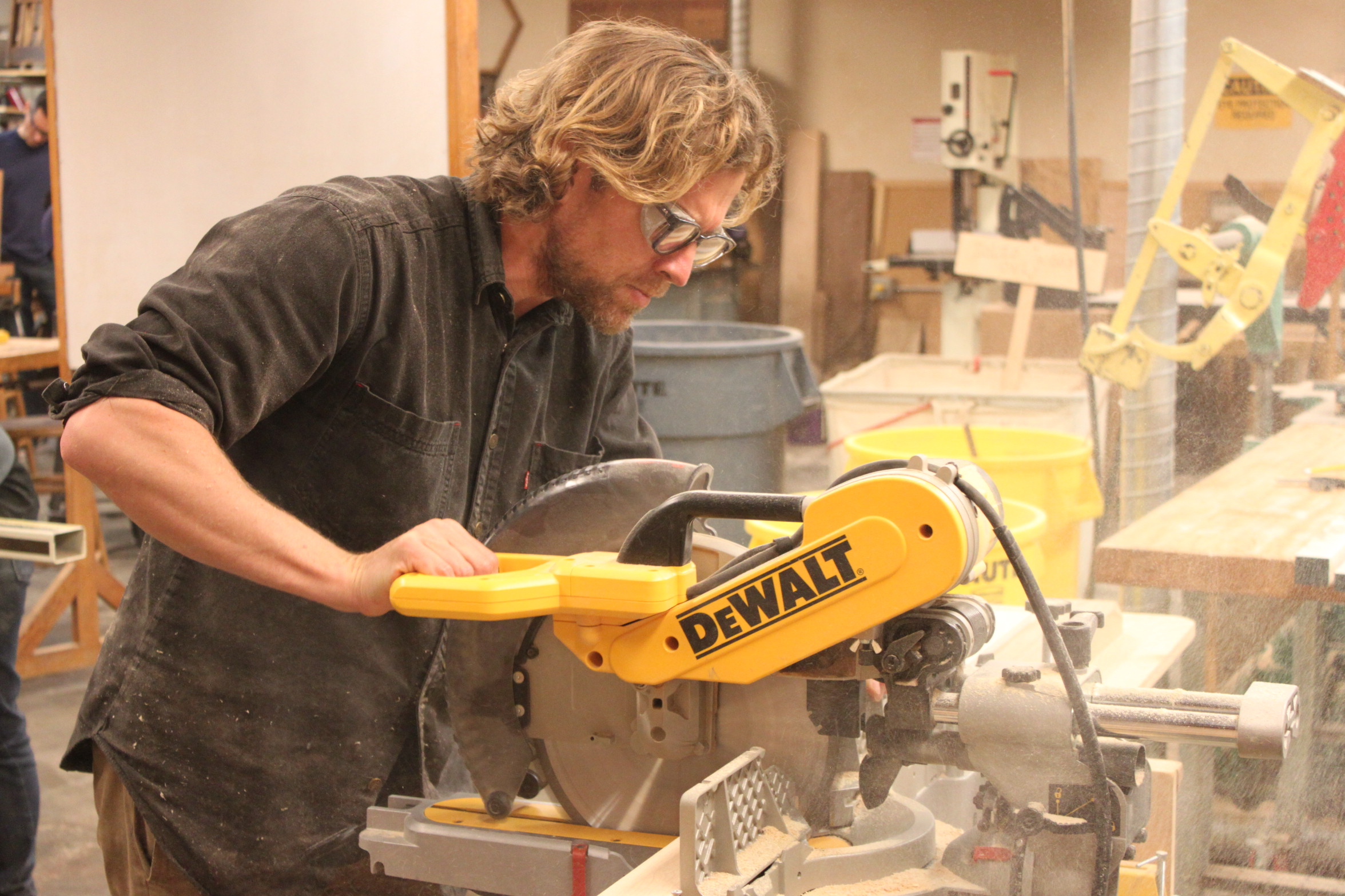 Sawdust flies as industrial design major, Trevor Rogers, works on cabinets for his apartment using a compound miter saw. Photo taken on Oct. 27, 2017.  