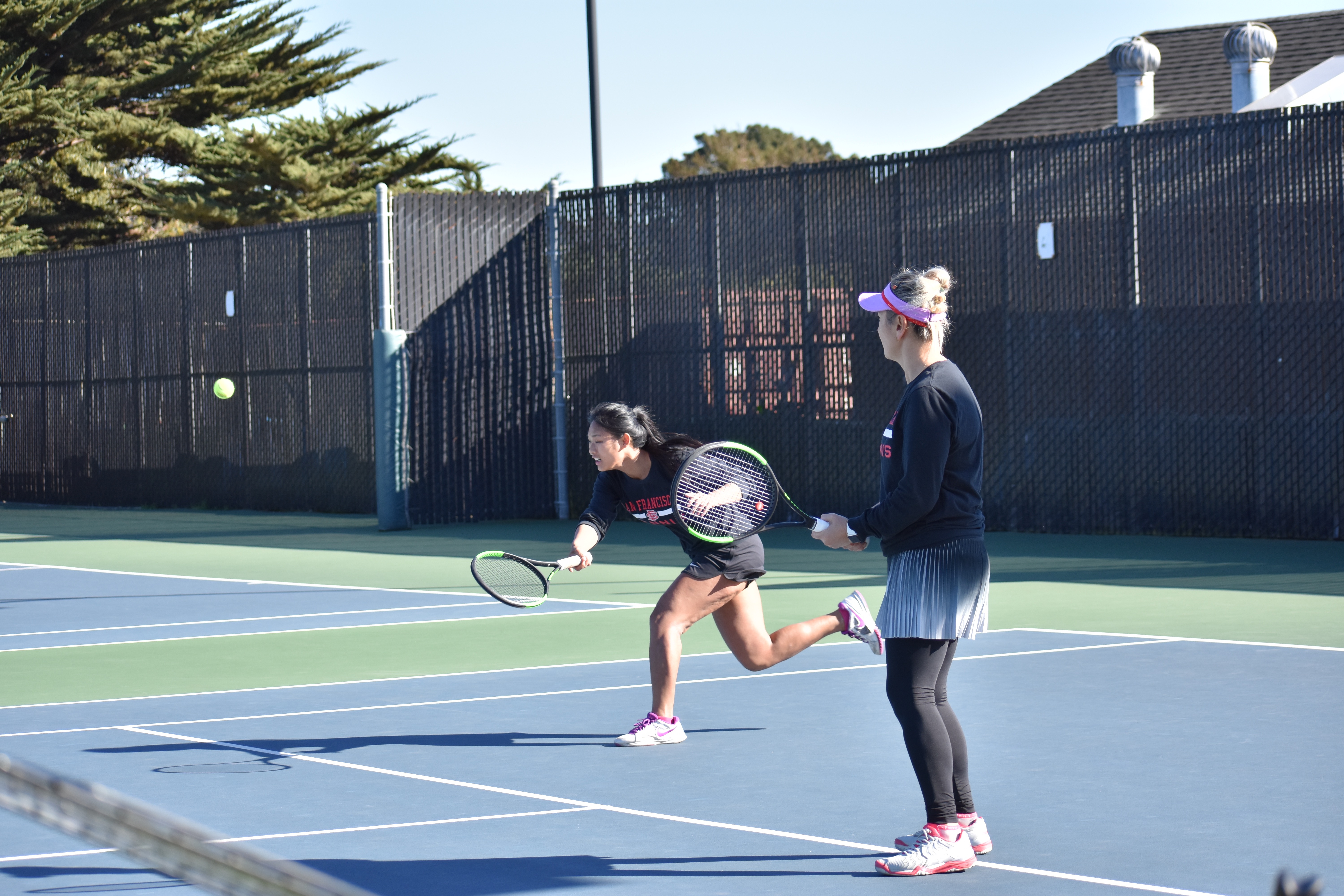 Ram's No. 1 ranked doubles players sophomore Yvonne Ng (left) and sophomore Zee Aynaci return rally against opponent Cañada College on Feb. 16, 2018. Photo by Veronica Steiner/The Guardsman. 